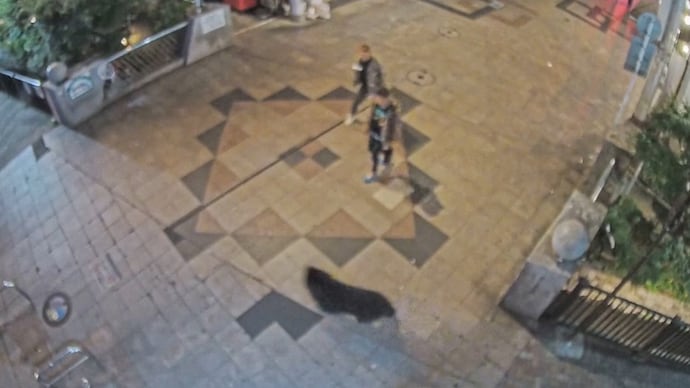 A screen grab from a surveillance footage shows a wild bear running past bystanders in a residential area in Utsunomiya, Tochigi Prefecture, Japan, June 7, 2026