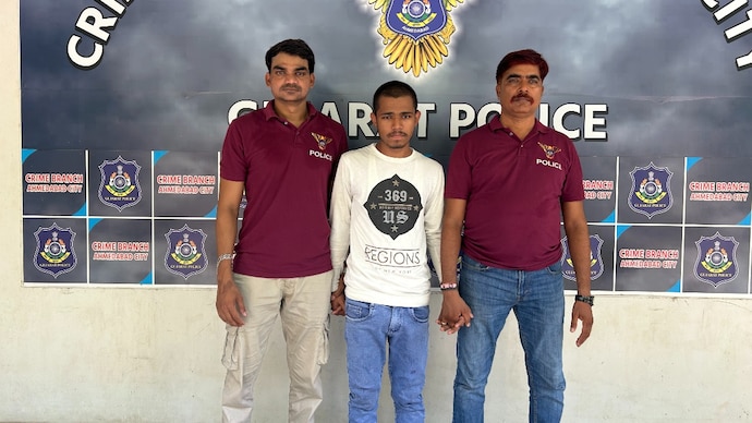 Ahmedabad Police officials with the arrested accused Naveen Yadav.