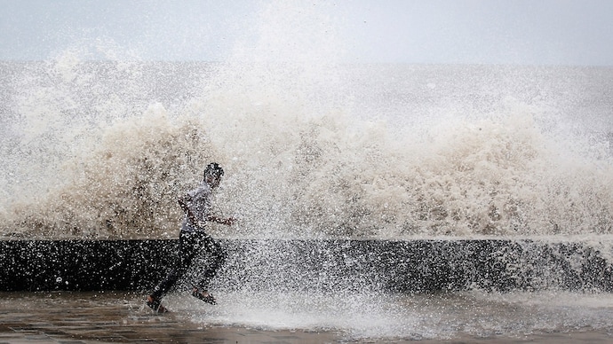 A school boy runs to get drenched in a large wave during high tide at a sea front in Mumbai. (Photo: Reuters) Coastal flooding