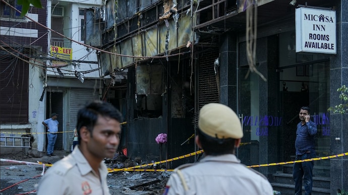 Delhi hotel fire: Police personnel stand guard near the site of a fire at a hotel in the Malviya Nagar area