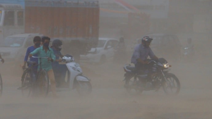 Commuters pass by dust storm (Photo- PTI)