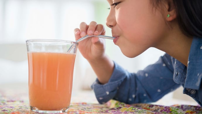 Filipino girl drinking juice on table