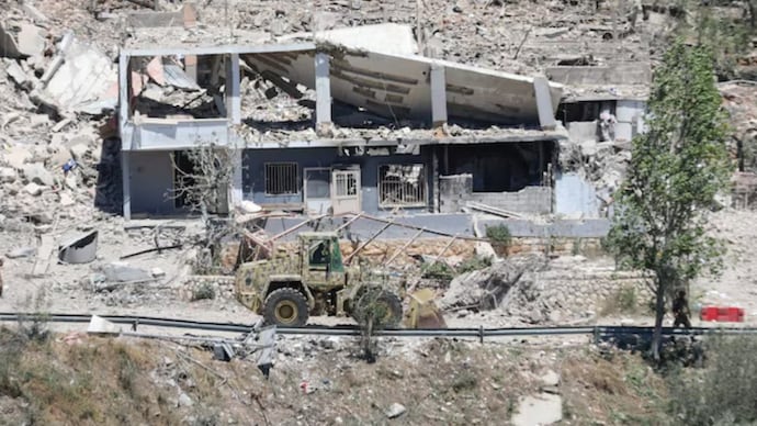 Machinery operates, as the Lebanese army opens a road, past buildings destroyed during the Israeli military campaign, in Dibbin, southern Lebanon. (Photo: Reuters)