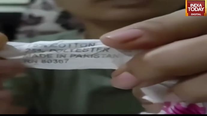 Woman displays a 'Made in Pakistan' label found on a bedsheet after washing. 'Made in Pakistan' label found on bedsheet bought at Pune fair