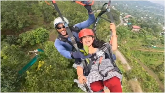 Paragliding pilot reaches for treetops mid-air to gift woman leaves