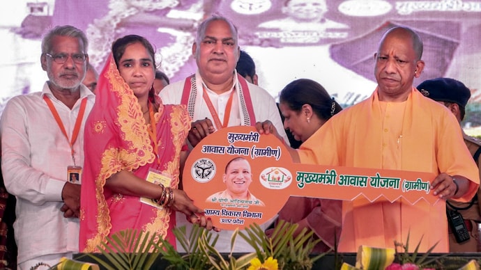 Uttar Pradesh Chief Minister Yogi Adityanath presents a demo key to a beneficiary under the Mukhyamantri Aawas Yojna during the foundation stone laying ceremony of various projects, in Hathras, Uttar Pradesh, Sunday, June 28, 2026. (PTI Photo)