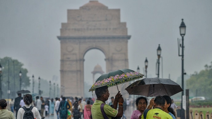 People visit Kartavya Path amid rain, in New Delhi. (Photo: PTI) All eyes on the sky: Heavy rain alert. Will monsoon finally hit Delhi-NCR today?