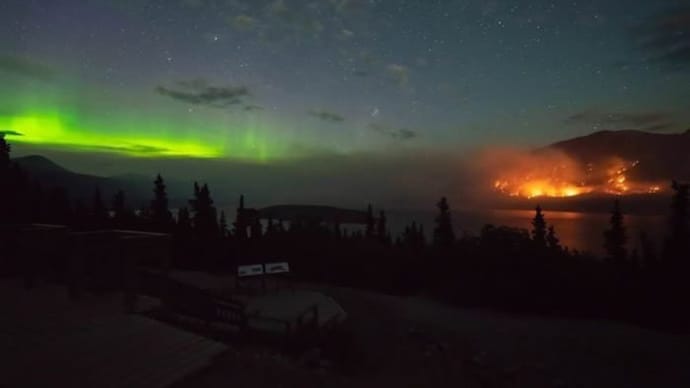 Aurora borealis ripples in green over the Windy Arm wildfire near Tagish Lake, Yukon, in a photo resurfacing amid Canada's 2026 fire season. (Photo: X/@CyberPunkCortes)