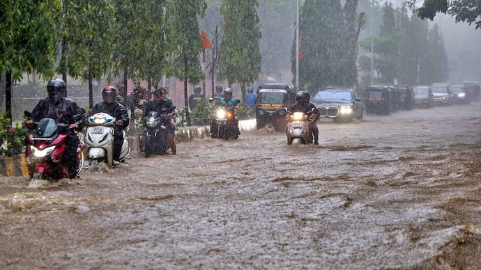 Commuters wade through a waterlogged road amid rainfall, in Mumbai. (Photo: PTI) Commuters wade through a waterlogged road amid rainfall, in Mumbai. (Photo: PTI)