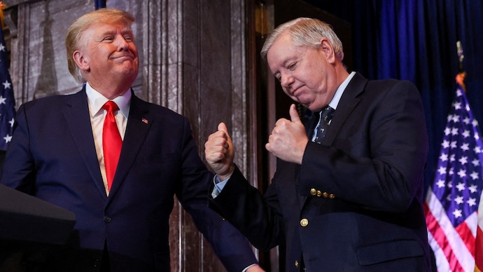 US Senator Lindsey Graham gestures, while standing next to US President Donald Trump.