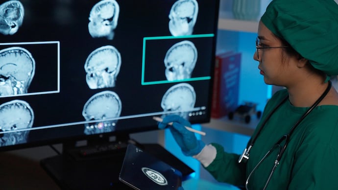 Female surgeon looks at screen with MRI scan with brain Images .futuristic animation. Doctor Analyzing CT/ MRI Brain Scan Images . examined the patient's X-ray results In the laboratory .X-ray analyzing.