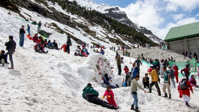 Tourists gather near snow-covered mountains at the Atal Tunnel North Portal, in Lahaul and Spiti district(PTI Photo)