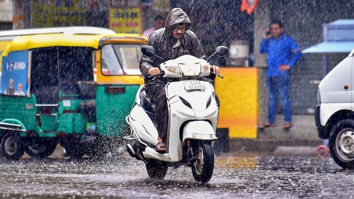 A man rides a scooter through a rain-soaked road during rainfall, in Rajkot, Thursday, July 2, 2026. (PTI Photo) Monsoon rain Gujarat