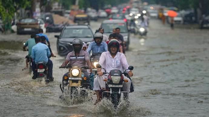 Commuters make their way through a waterlogged road following heavy rain. (Photo: PTI) Prepare for heavy rain on Saturday: IMD cautions Gujarat; Bihar to be on edge