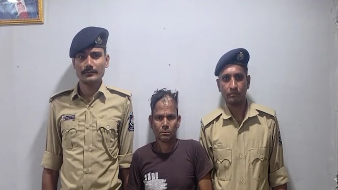 The accused, Babubhai Pargi, with Gujarat Police personnel after his arrest.