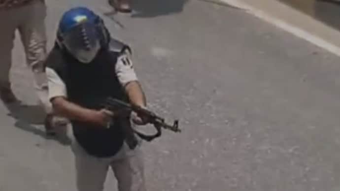 The cop was seen firing at least three rounds from an AK-47 rifle.