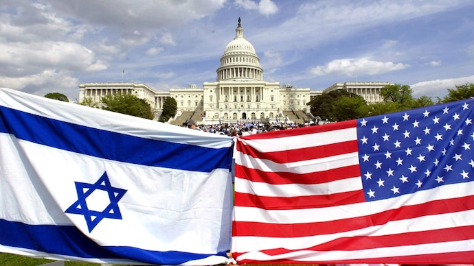 A US flag is held beside an Israeli flag in front of the US Capitol (File Photo: Reuters)