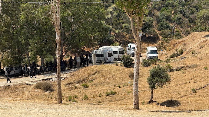 Moroccan police and gendarmerie officers, accompanied by auxiliary forces wearing riot gear, walk down a hill after blocking an attempted border crossing by migrants into Spain in Fnideq, Morocco, August 15, 2026. (Photo- Reuters)