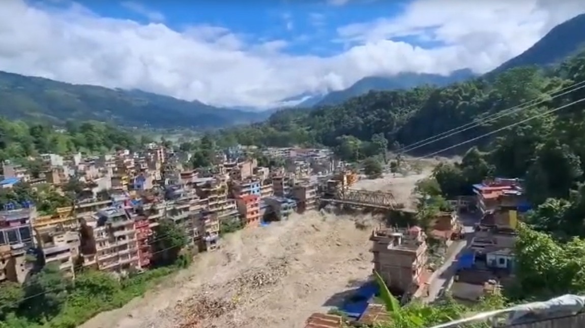 w=380 Partially submerged buildings and debris along the Trishuli River after the flood