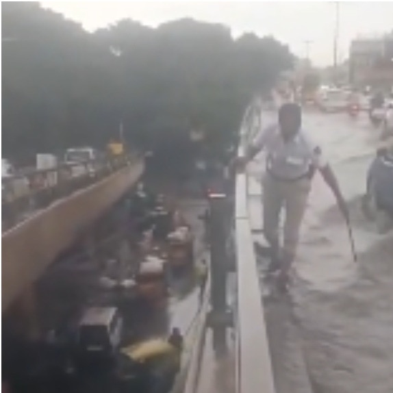 Bengaluru traffic cop clears drain on flooded flyover as vehicles struggle to pass