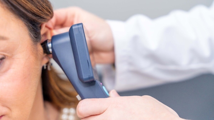Close-up of a female doctor examines the patient's ear with an otoscope Close-up of a female doctor examines the patient's ear with an otoscope