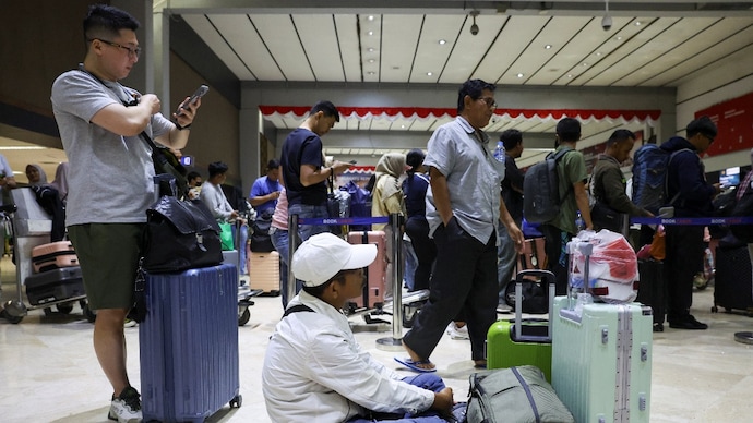 Stranded passengers wait at check-in area as Soekarno Hatta International Airport closed its operations due to the eruption of the Mount Anak Krakatau volcano. (Credits: Reuters)