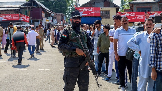 A security personnel stands guard as Kashmiri Pandit devotees wait in a queue to offer prayers at Kheer Bhawani temple in Tullamulla Ganderbal, Jammu and Kashmir. (Image: Getty Images) kashmiri pandits srinagar jammu and kashmir united liberation front ulf ulf lashkar e taiba threat letter