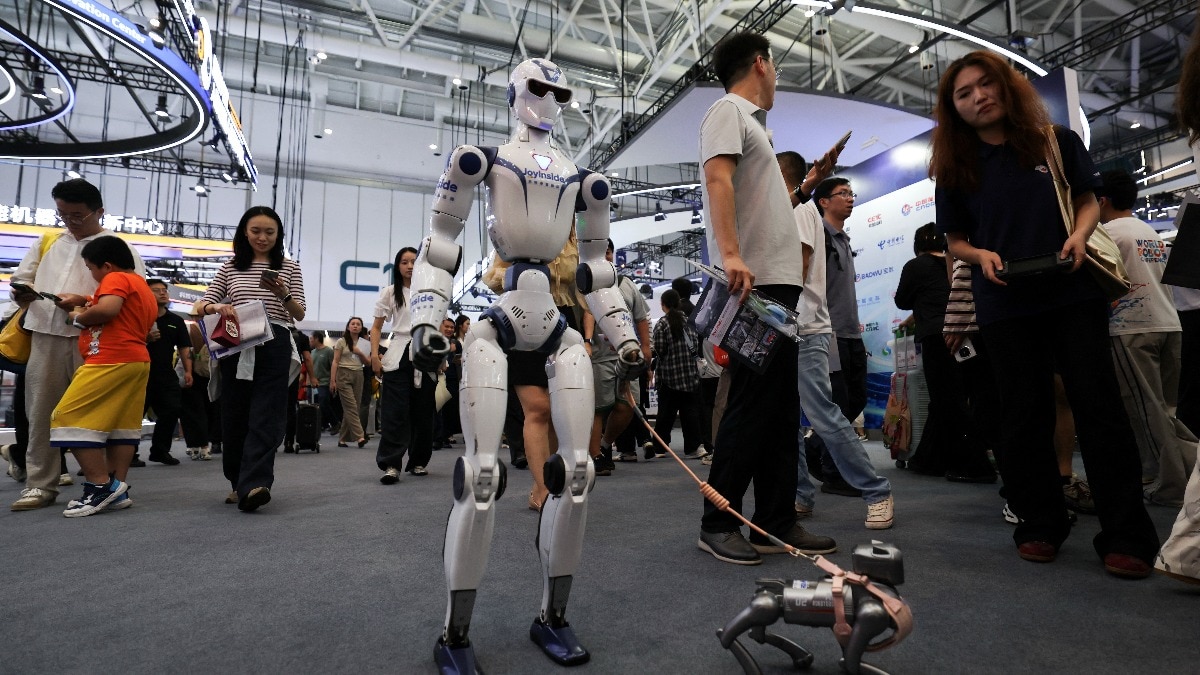 A Unitree's R1 humanoid robot with JD.com's JoyInside AI platform walks a robot dog during the 2026 World Robot Conference, in Beijing, China. ( Photo- Reuters)