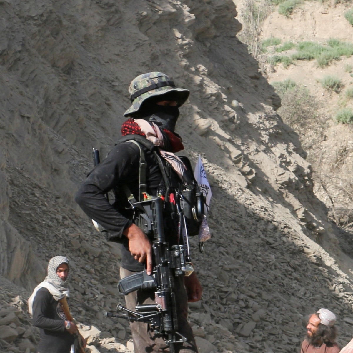 A Taliban security member stands on top of the debris of a house following an airstrike that the Taliban said was carried out by Pakistan