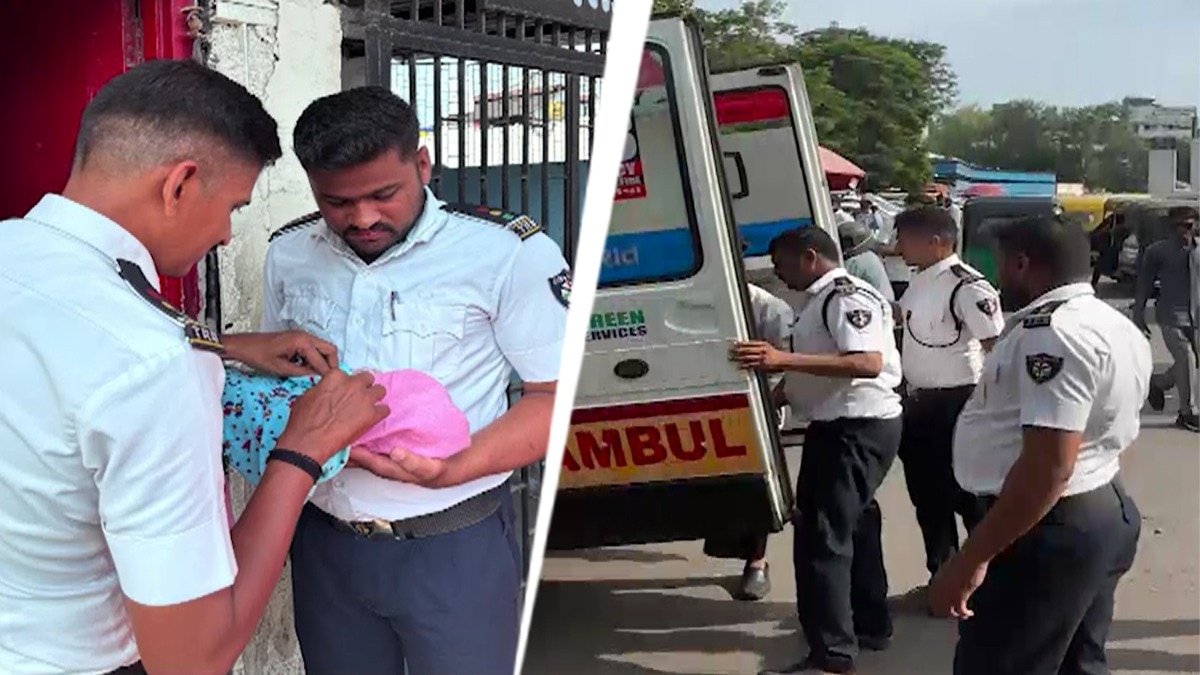 Traffic police personnel hold the newborn after a woman gave birth at a traffic police chowki outside Surat Railway Station. (Source: ITG)