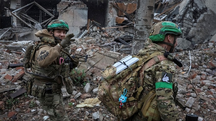 Ukrainian servicemen walk past a damaged apartment building in the frontline town of Druzhkivka on Tuesday. (Photo: Reuters/File)