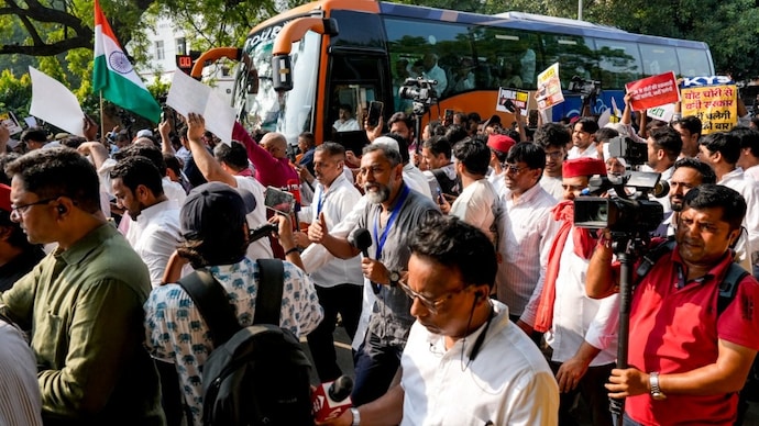 Supporters walk along a bus carrying INDIA bloc leaders as they proceed towards Supreme Court during a protest march in New Delhi, on Monday, October 12, 2026. (PTI Photo) Delhi Protest