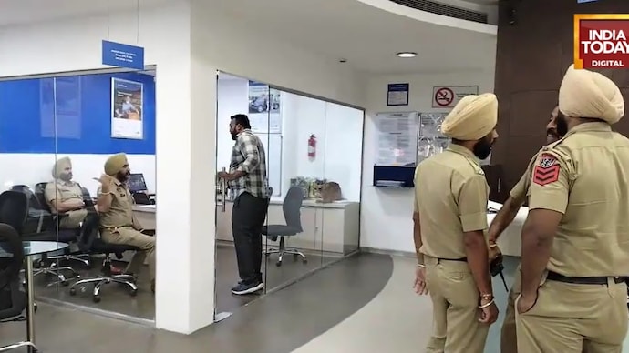 Police personnel inspect the scene inside a bank in Amritsar after a firing incident triggered by a financial dispute left several people, including a loan department manager, injured. Firing over financial dispute inside Amritsar bank