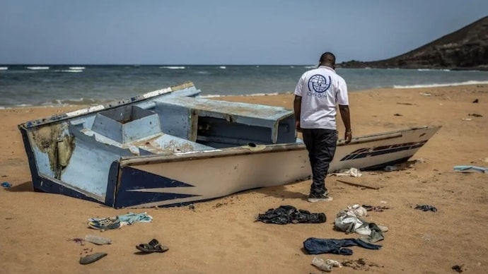 This file photo shows a member of the Organization for Migration (IOM) inspecting the abandoned wreckage of a boat that capsized while attempting to transport migrants to Yemen. (AFP)