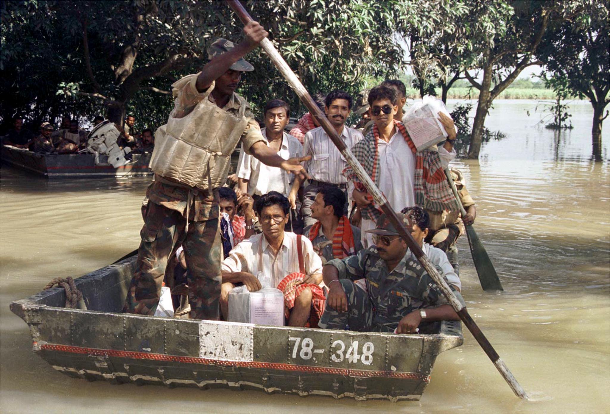 A soldier steers a boat carrying election officials and ballot boxes in Kolkata after floods. (Photo: Reuters)