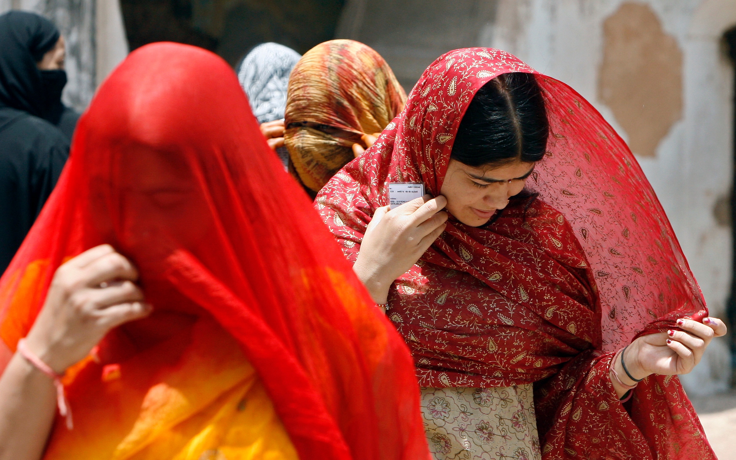 Women cover their faces from the heat in old quarters of Delhi. (Photo: Reuters)