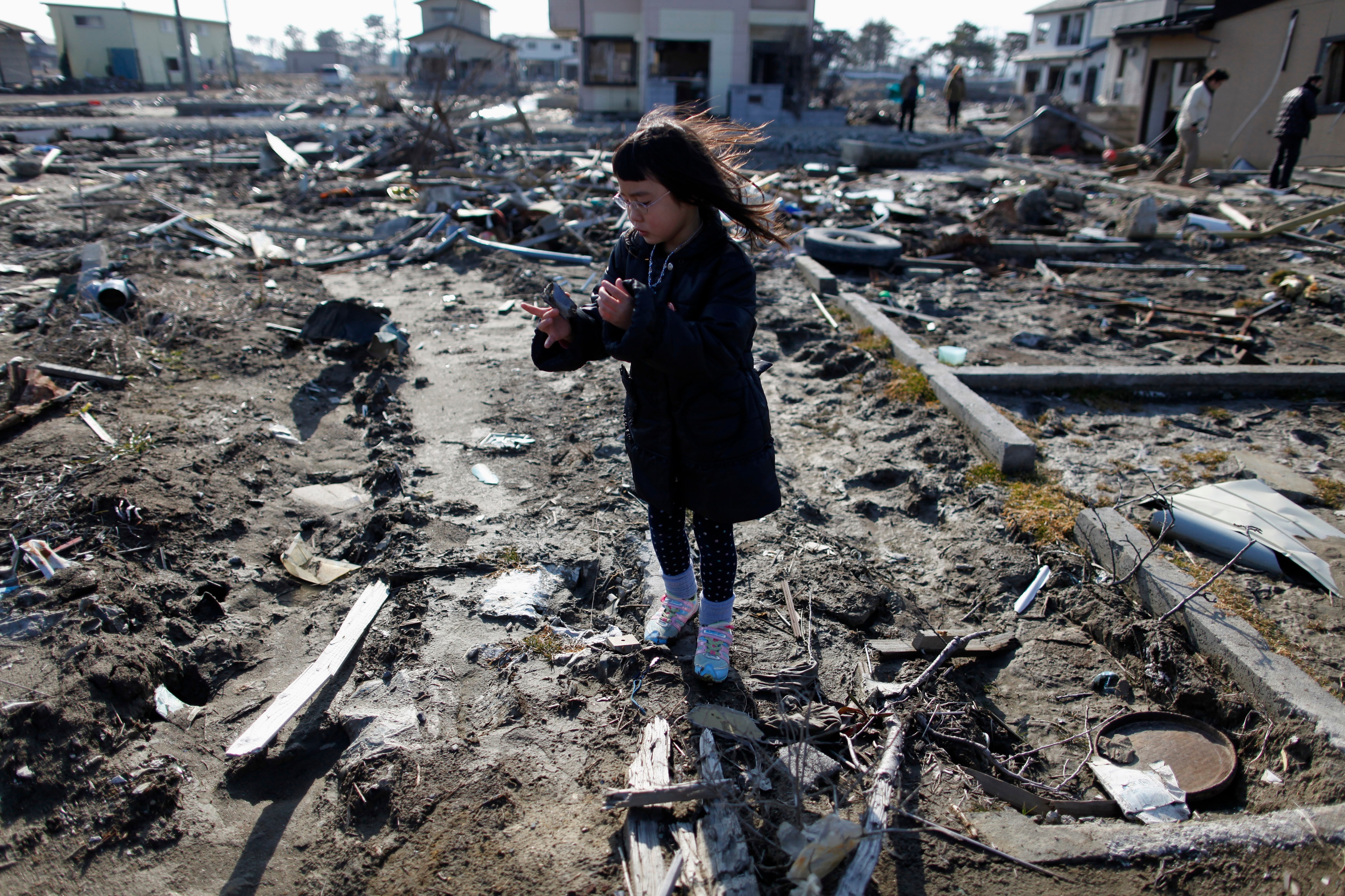 A girl visits the spot where her house stood, which was washed away by the March 11, 2011 tsunami. (Photo: Reuters)