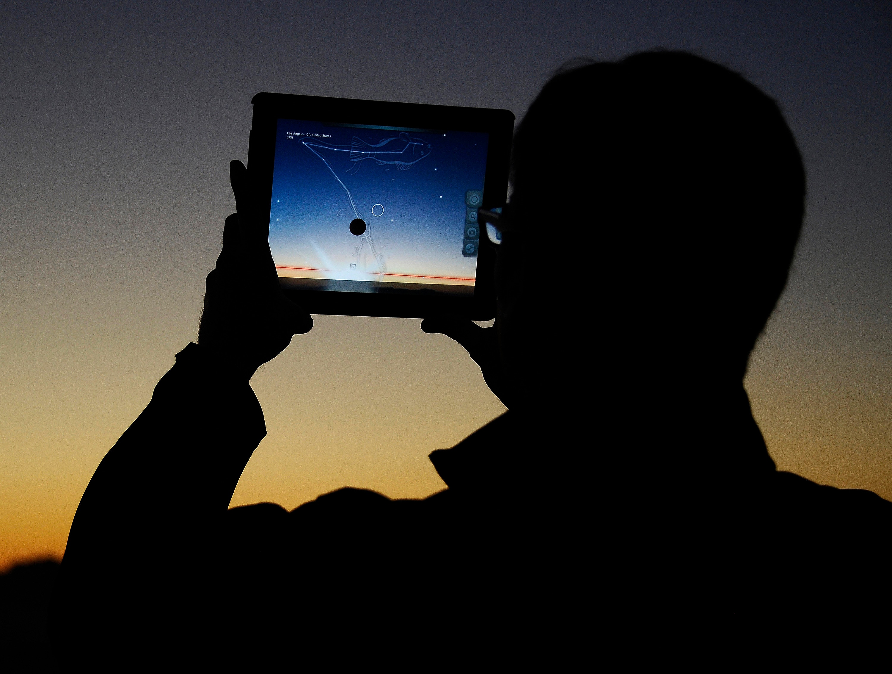 A man using an app on an iPad to line up the passing comet. (Photo: Reuters)