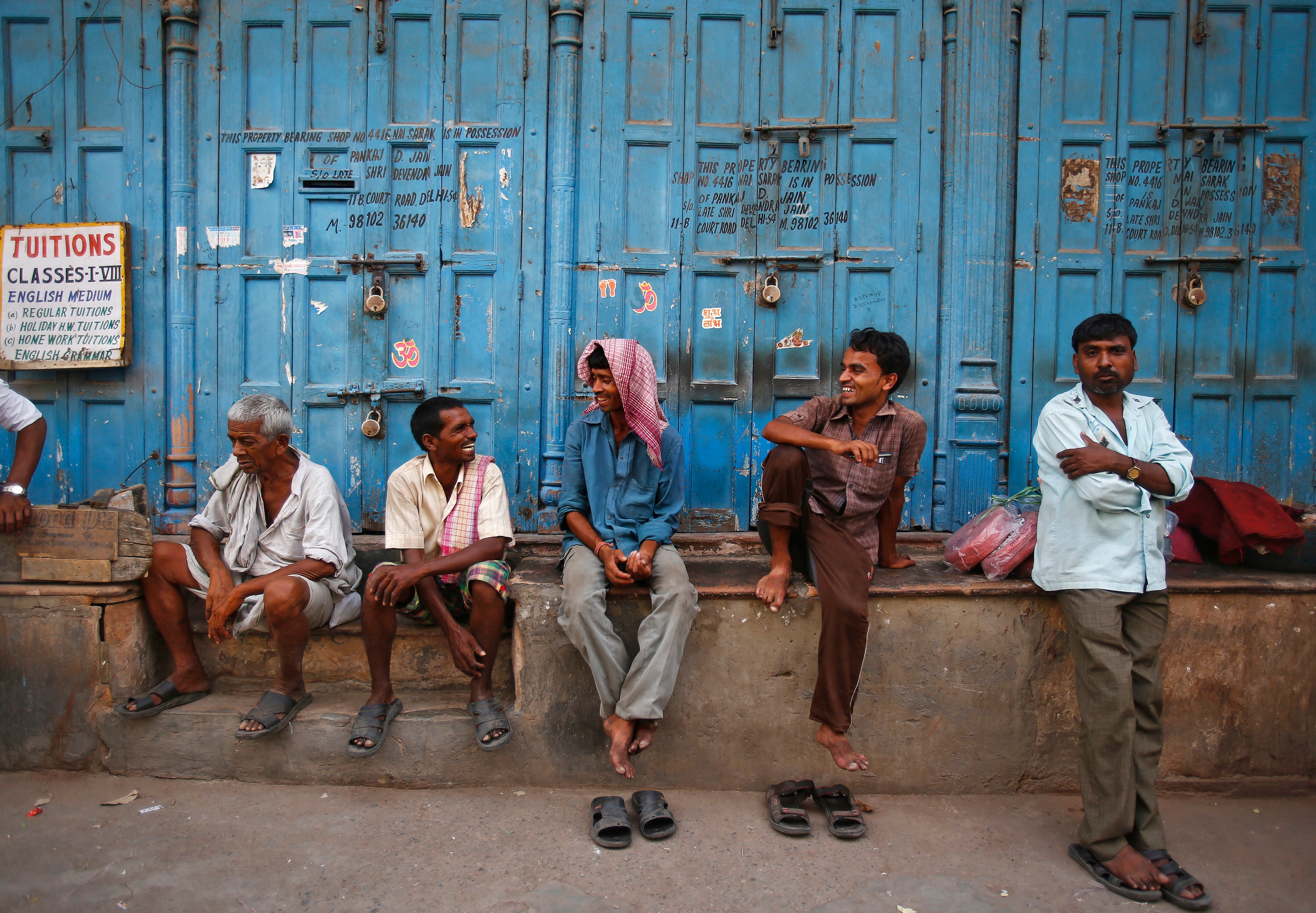 Workers take rest in front of closed shops on a hot summer day in the old quarters of Delhi. (Photo: Reuters)