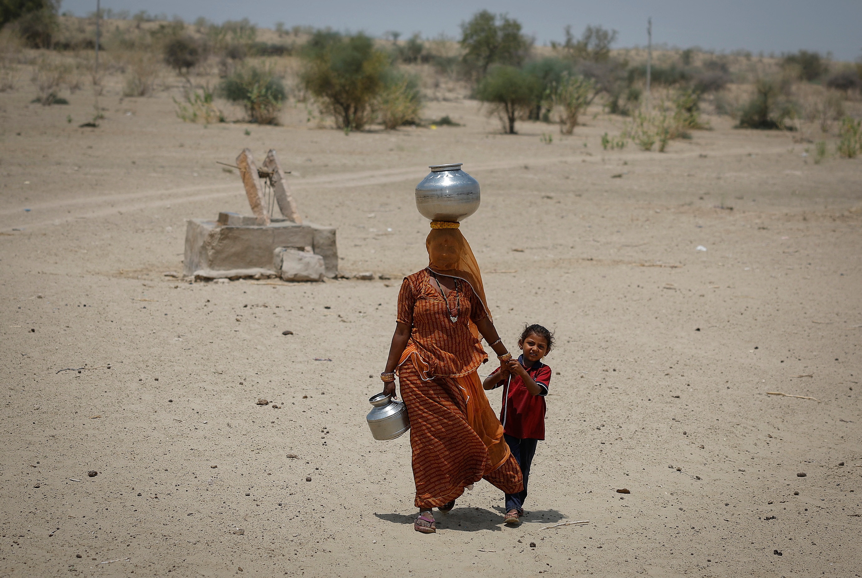 A woman walks back home after filling water from a well in a desert area in Rajasthan. (Photo: Reuters)