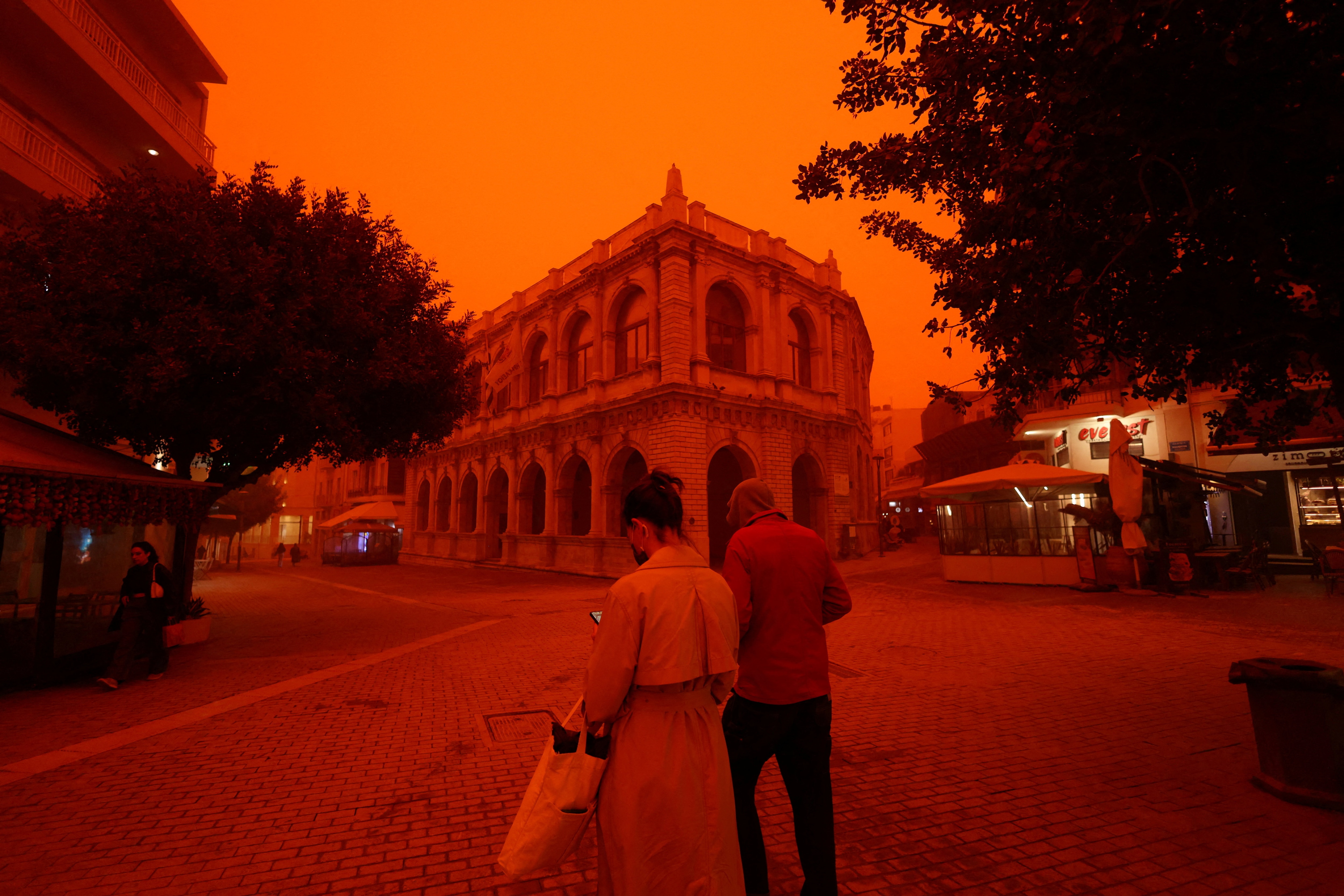 People walk amid a haze caused by sand dust from the Sahara, due to strong southern winds, in Heraklion, Crete island. (Photo: Reuters)