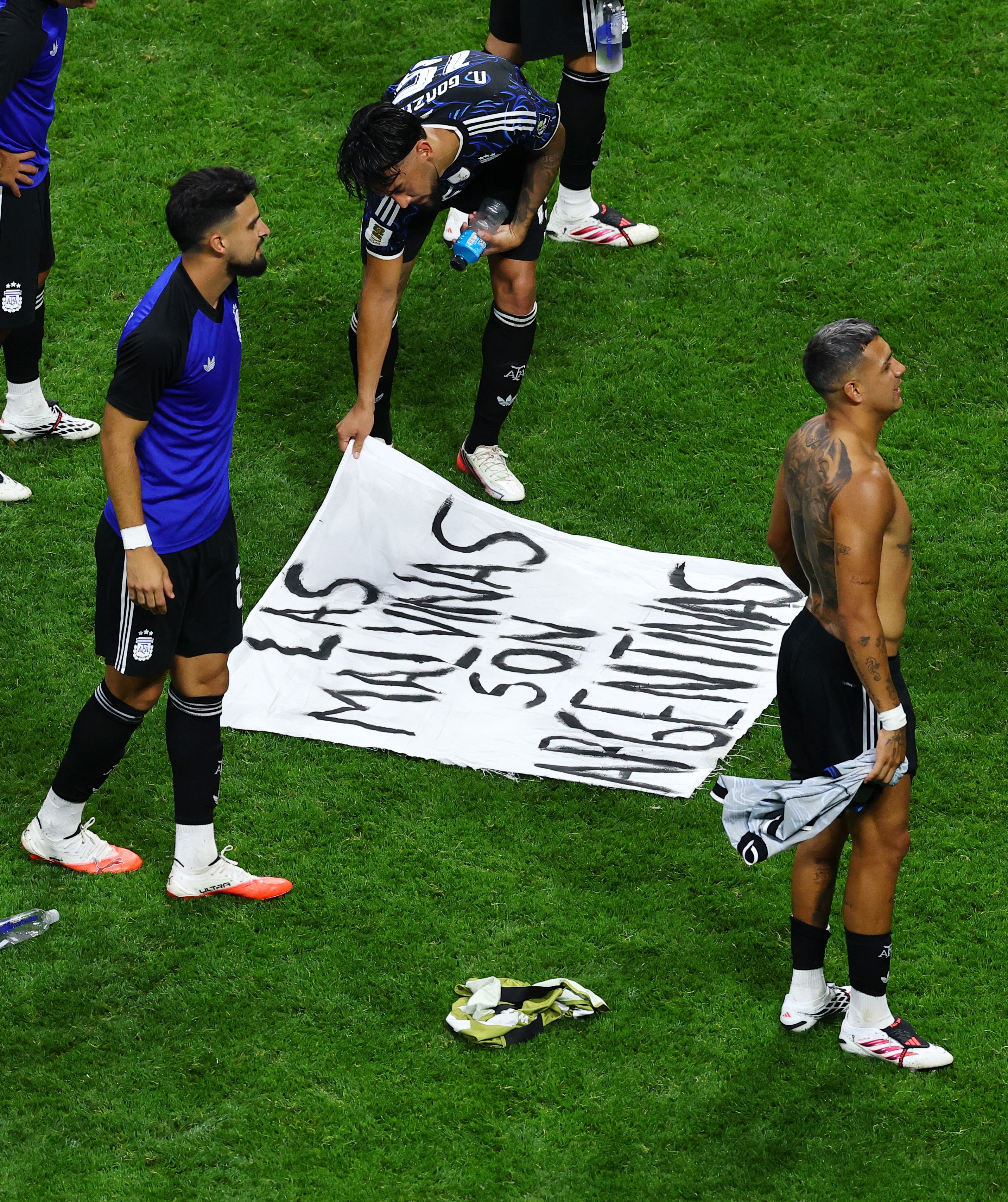 Argentina's Nicolas Gonzalez looks at a banner displaying a message referencing The Falkland Islands after the match. (Image: Reuters)