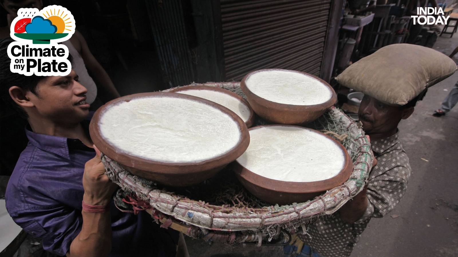 Labourers lift pots filled with curd from a roadside milk shop in Kolkata. (Photo: Reuters)
