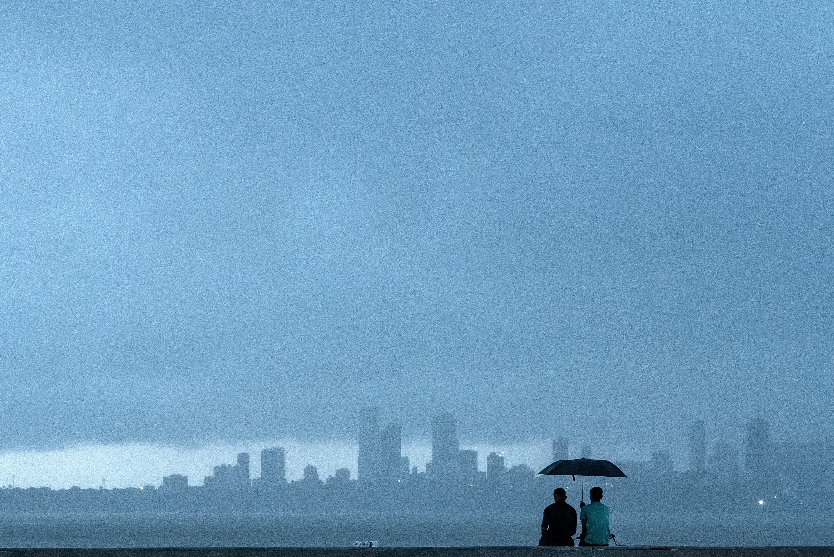 People sit under a cloudy weather prior to rain. (Photo: AFP)