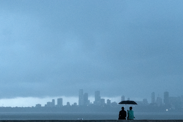 People sit under a cloudy weather prior to rain. (Photo: AFP)