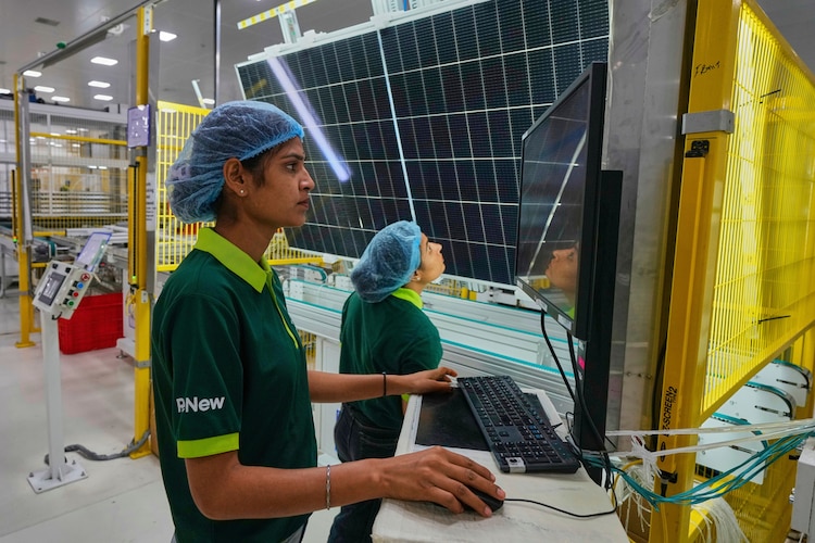 Workers check the quality of a solar panel at a ReNew manufacturing plant near Jaipur. (Photo: AP)