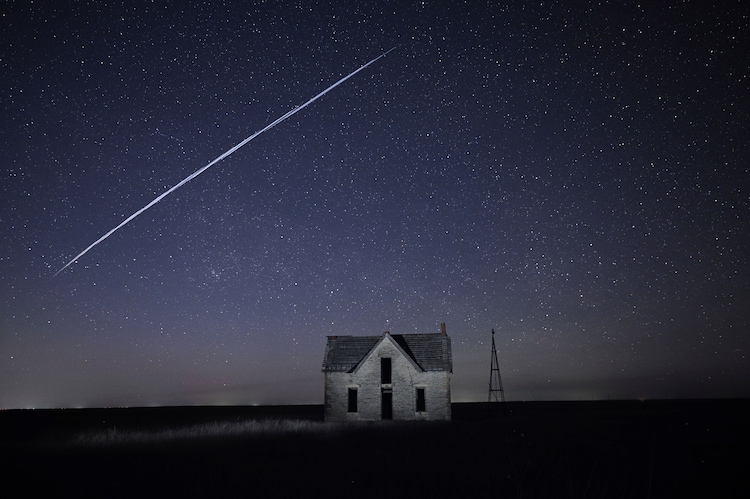A string of SpaceX StarLink satellites passes over an old stone house in the US. (Photo: AP)