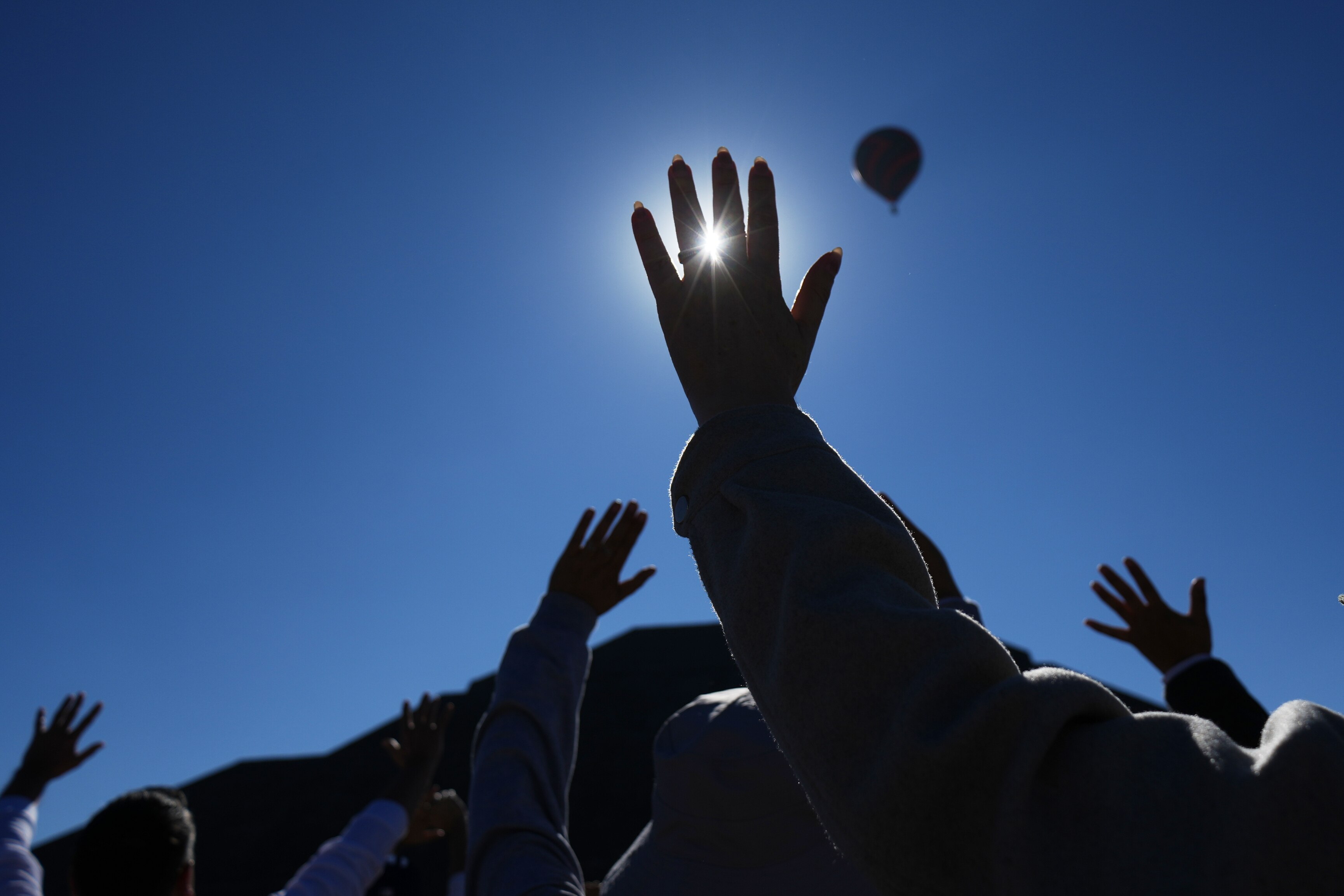 People raise their hands as the sun rises above the Pyramid of the Sun, as part of the Spring equinox celebrations in Mexico. (Photo: AP)