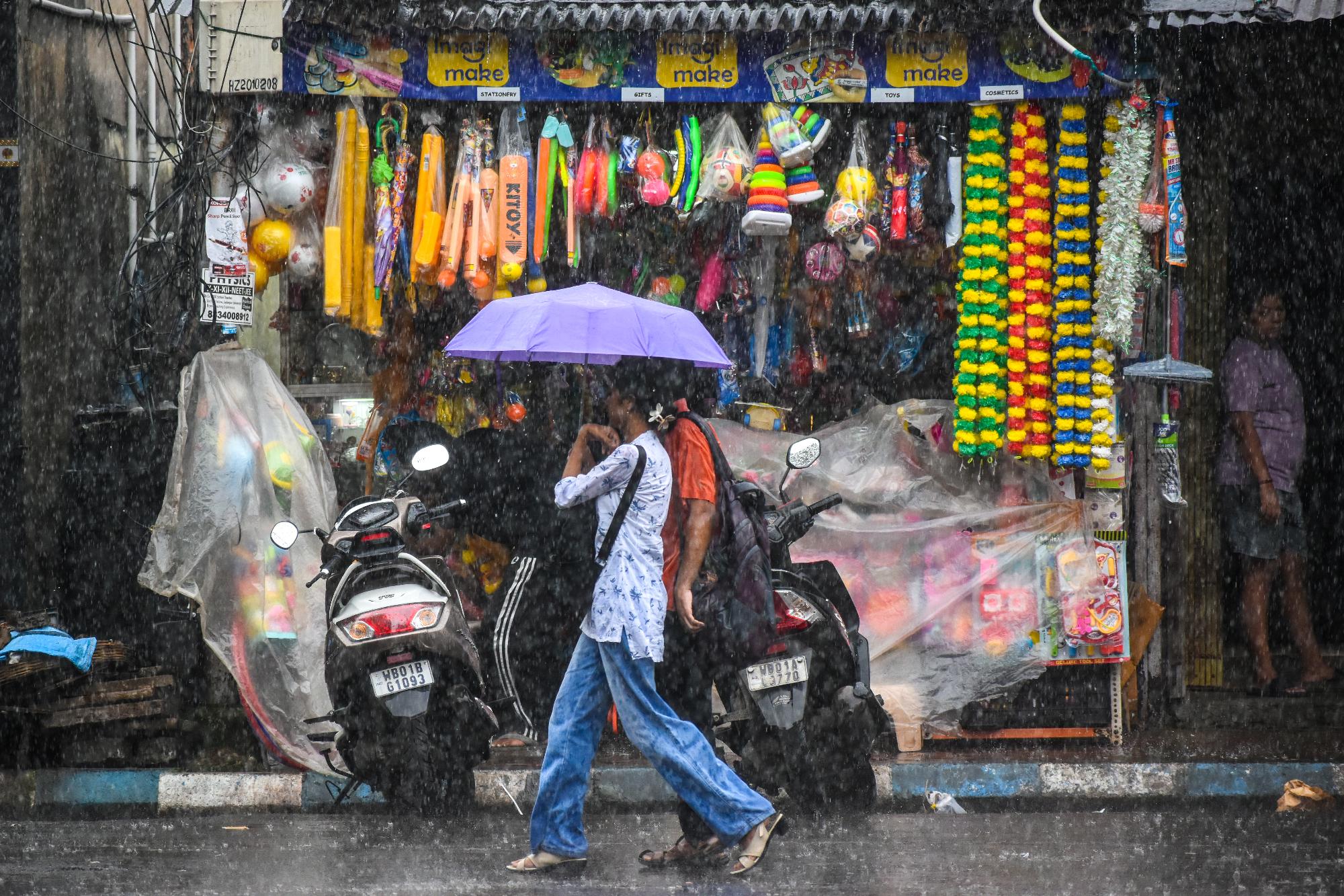 A boy walks with an un umbrella amid heavy rain. (Photo: Getty)