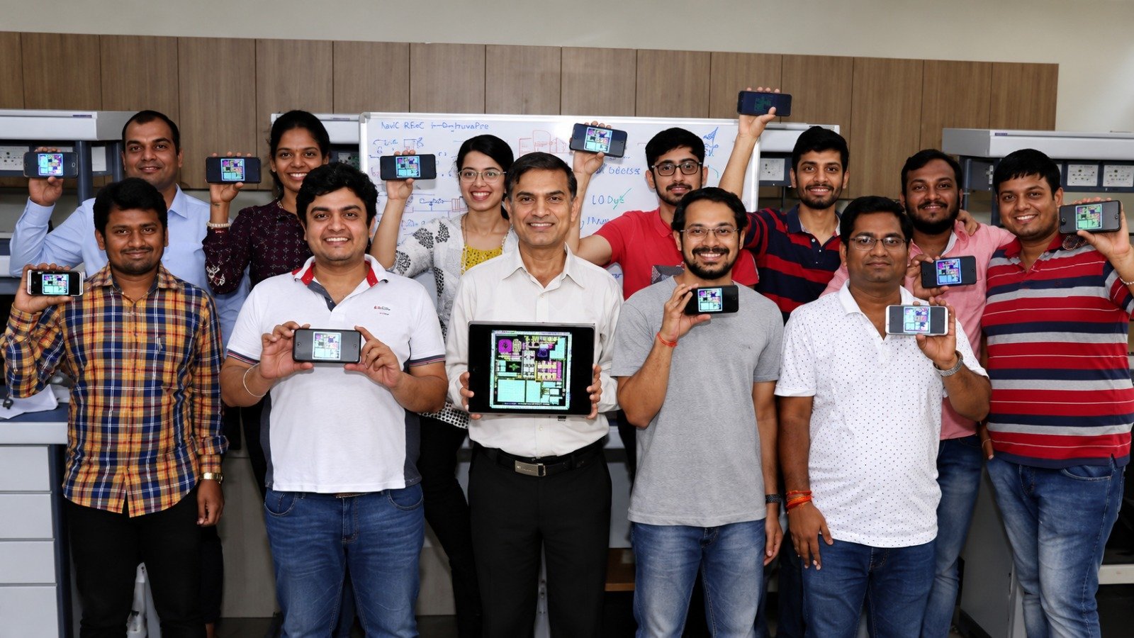 Members of the MumbaiSemi team are pictured while holding pictures of satellite chips. (Photo: MumbaiSemi)